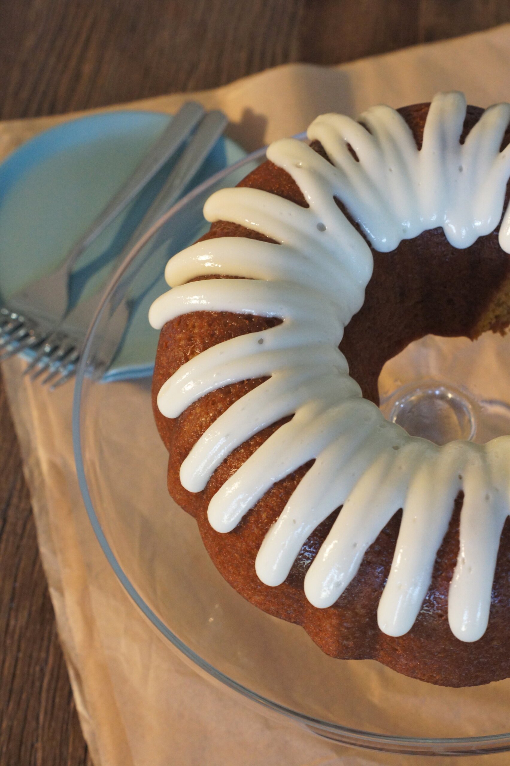 A close up of a pumpkin ginger bundt cake covered in cream cheese glaze