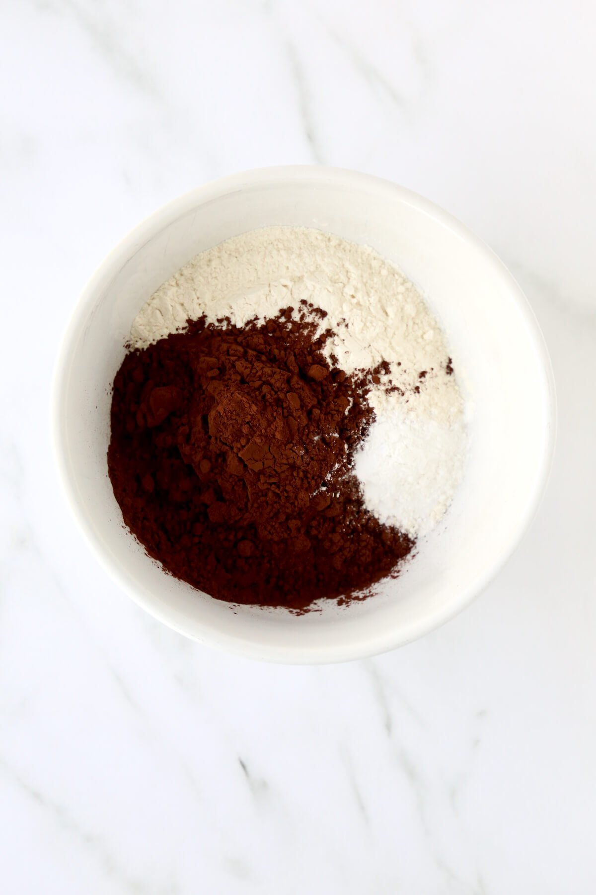A bowl of flour, cocoa powder and baking soda.  