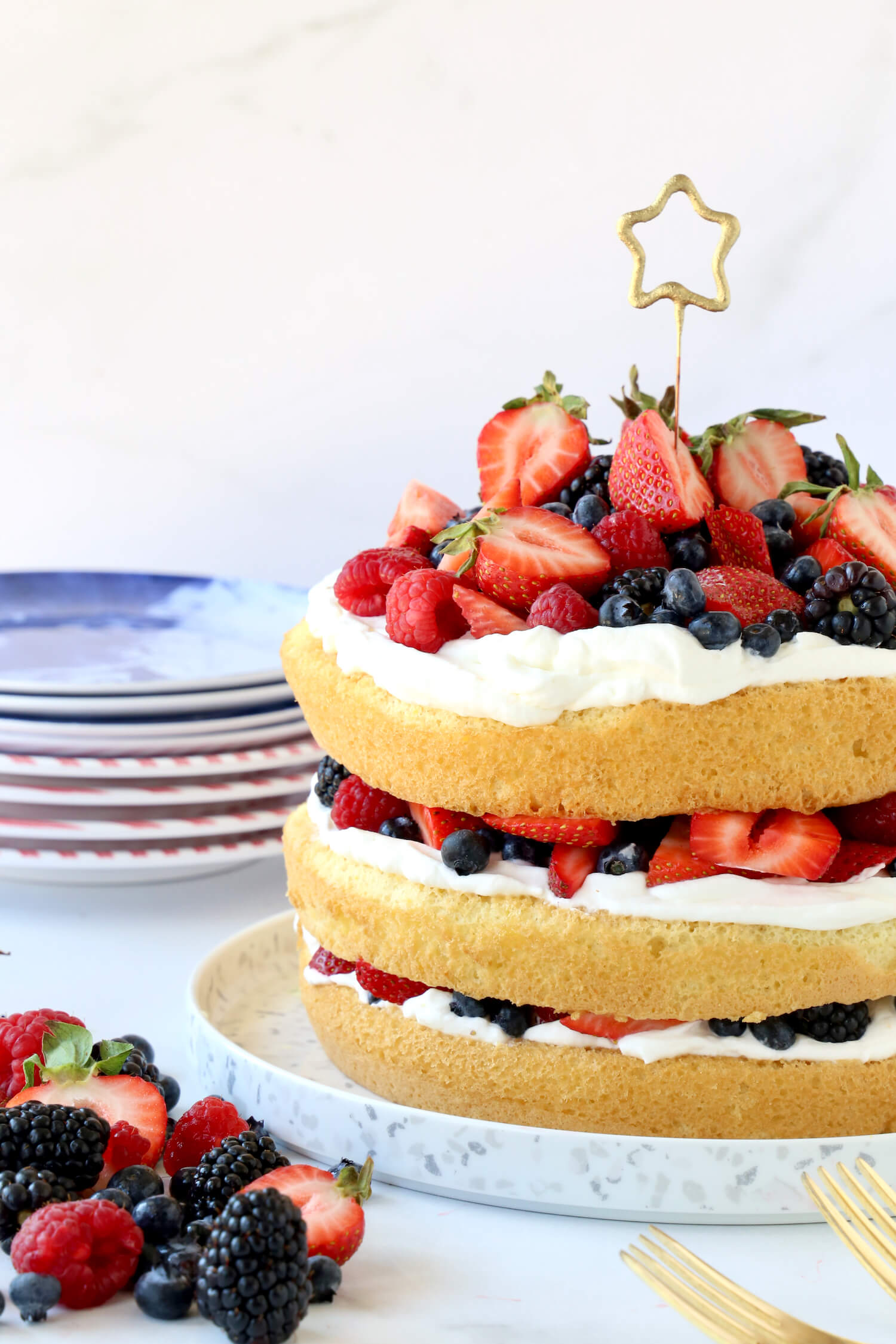 Three layers of sponge cake layered with fresh berries and whipped cream