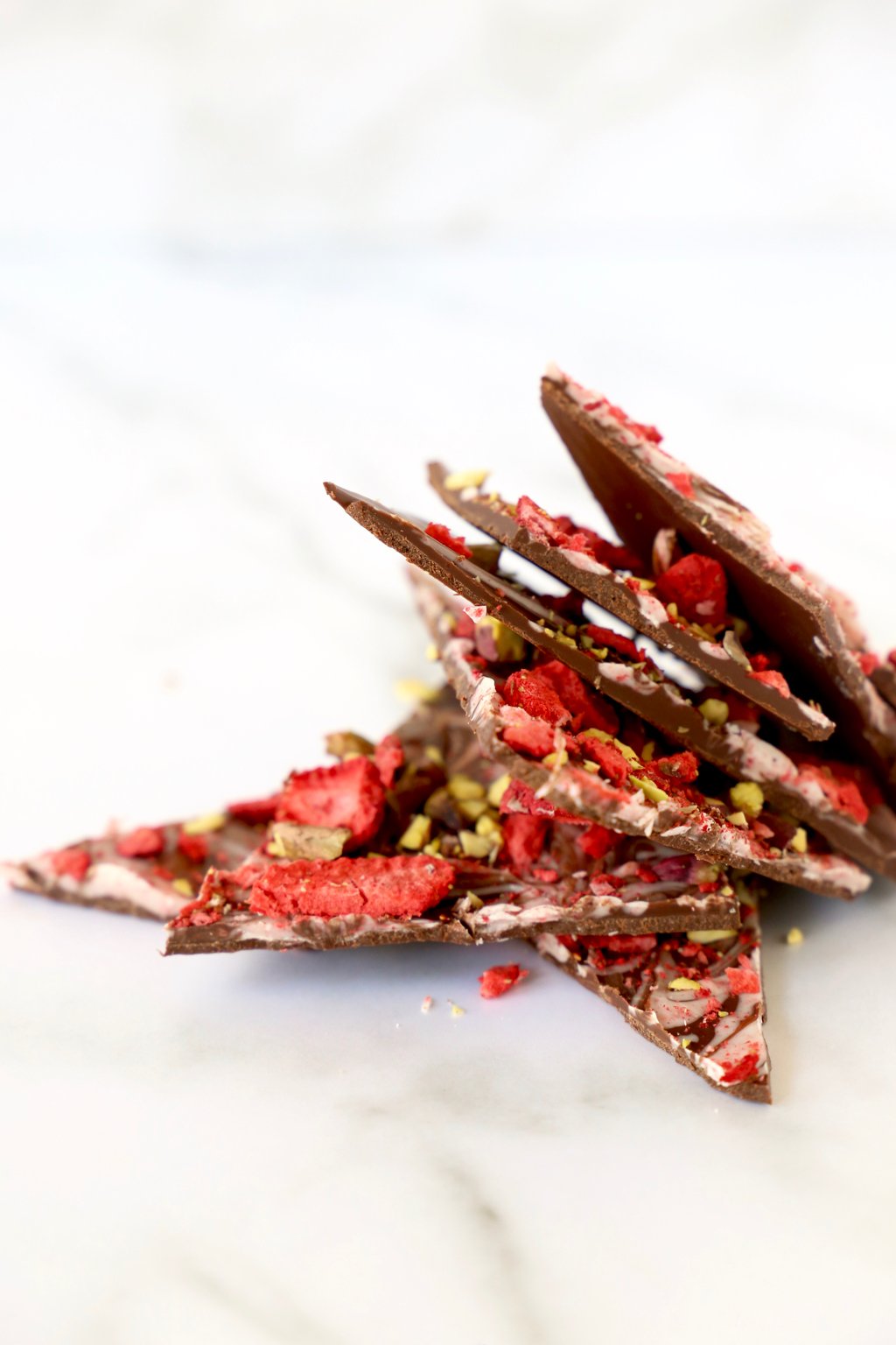 Pieces of strawberry pistachio bark stacked up