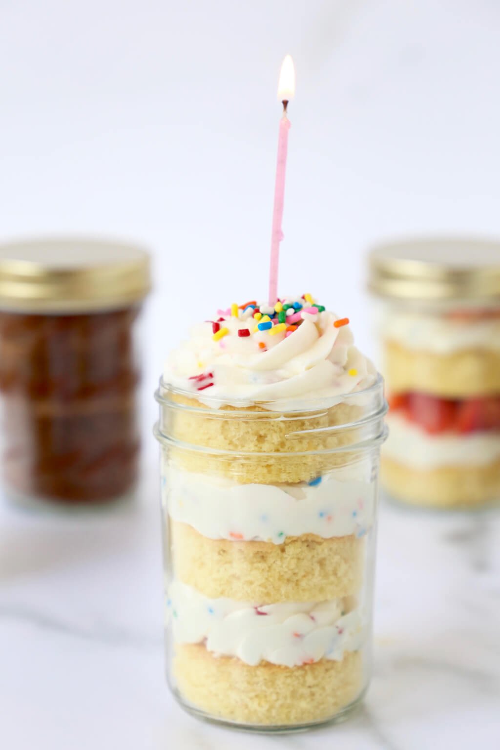 birthday candle lit in cake in a jar