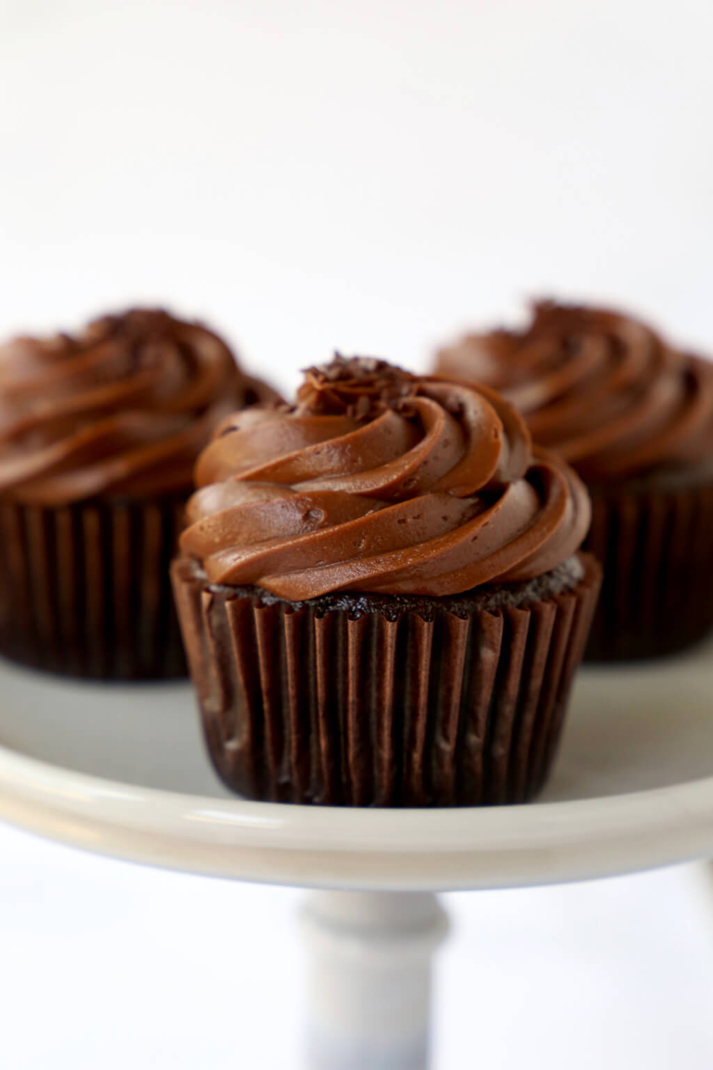 Three Chocolate Fudge Cupcakes on a cake stand