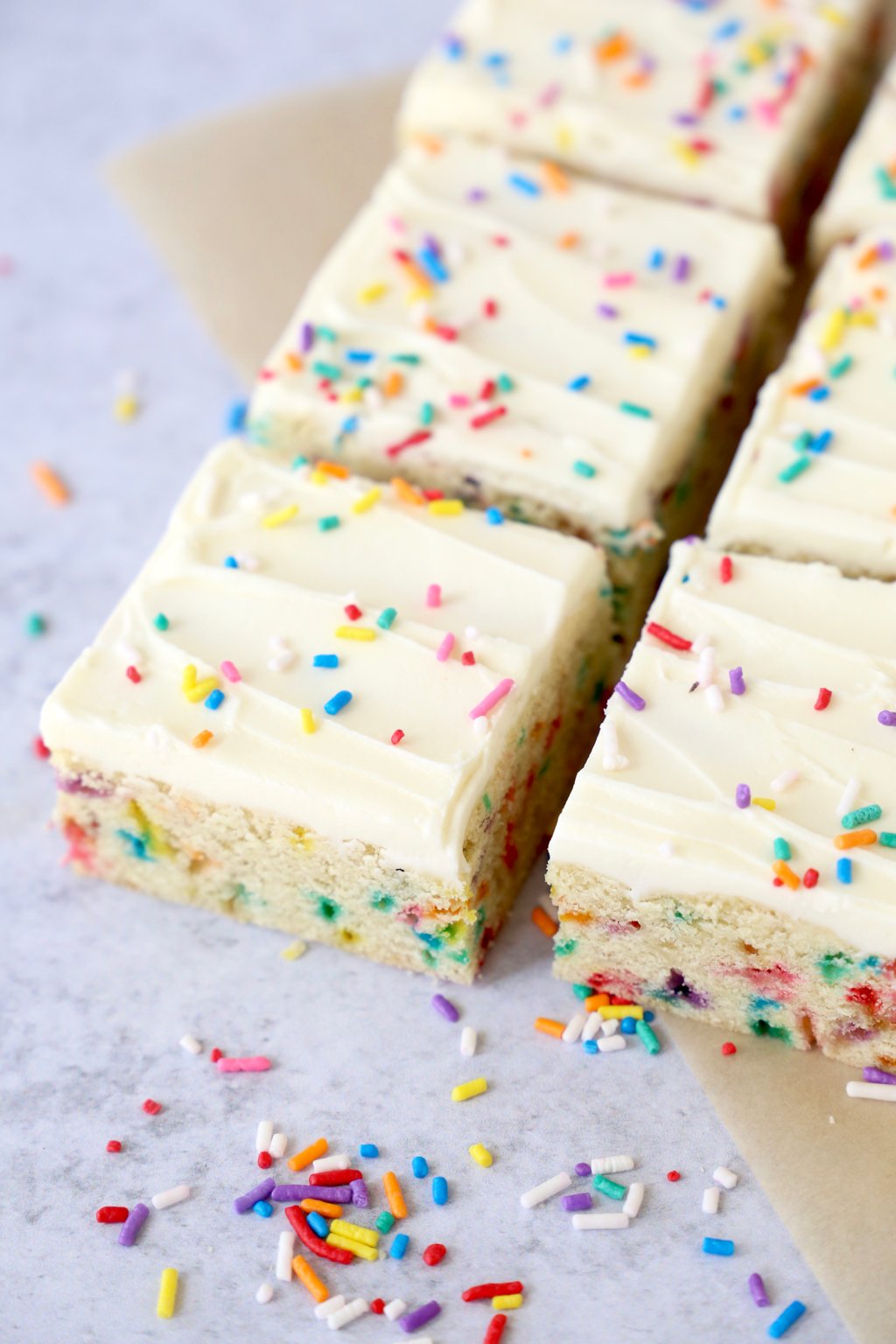 Frosted sugar cookie bars topped with rainbow sprinkles