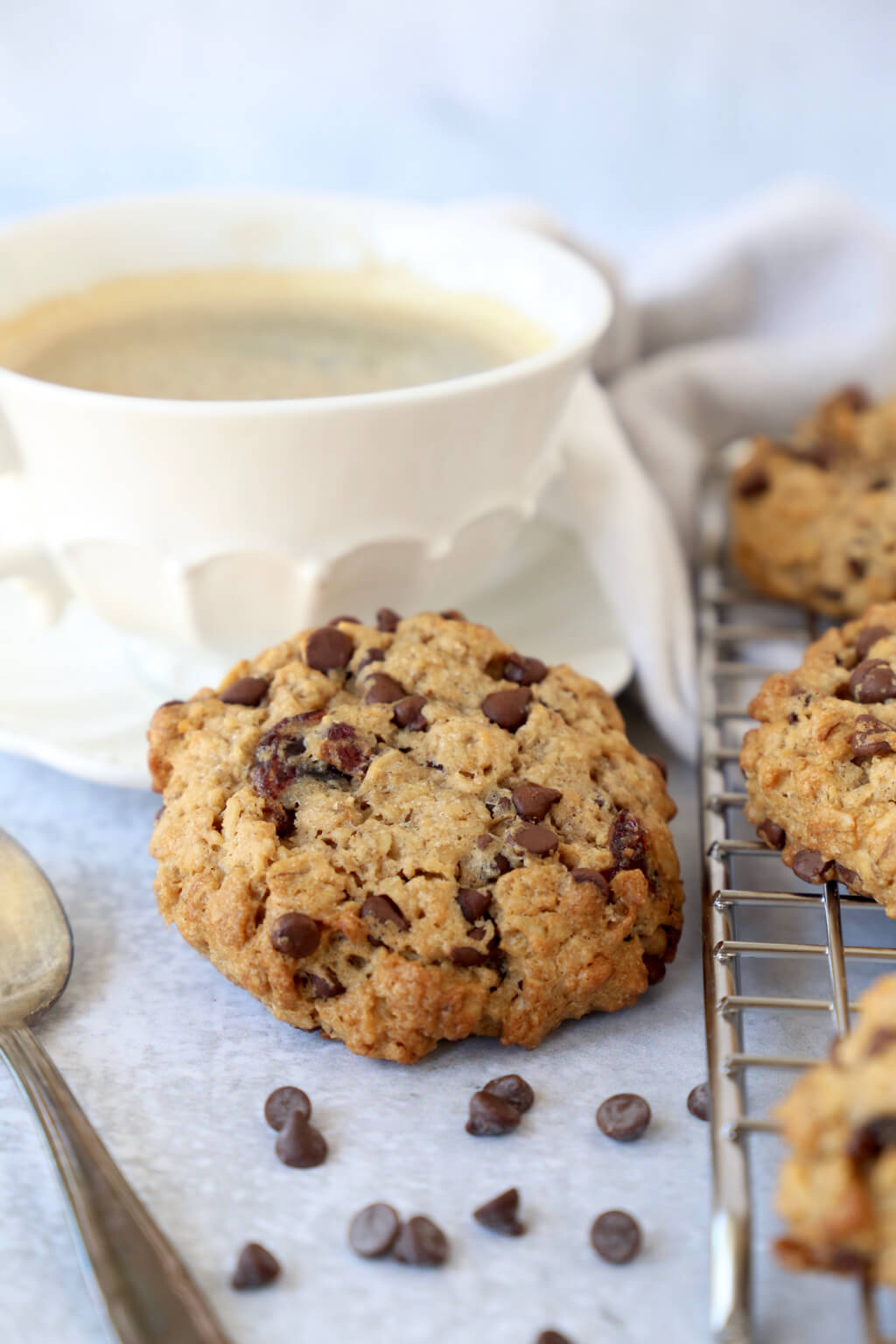 one breakfast cookie resting on the edge of a coffee cup