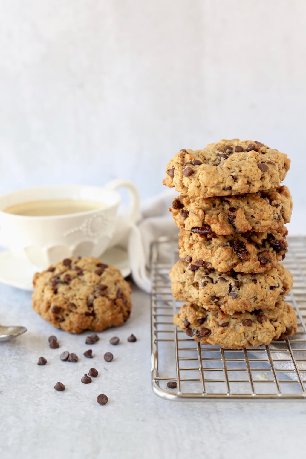 stack of five breakfast cookies on a cooling rack with a cup of coffee