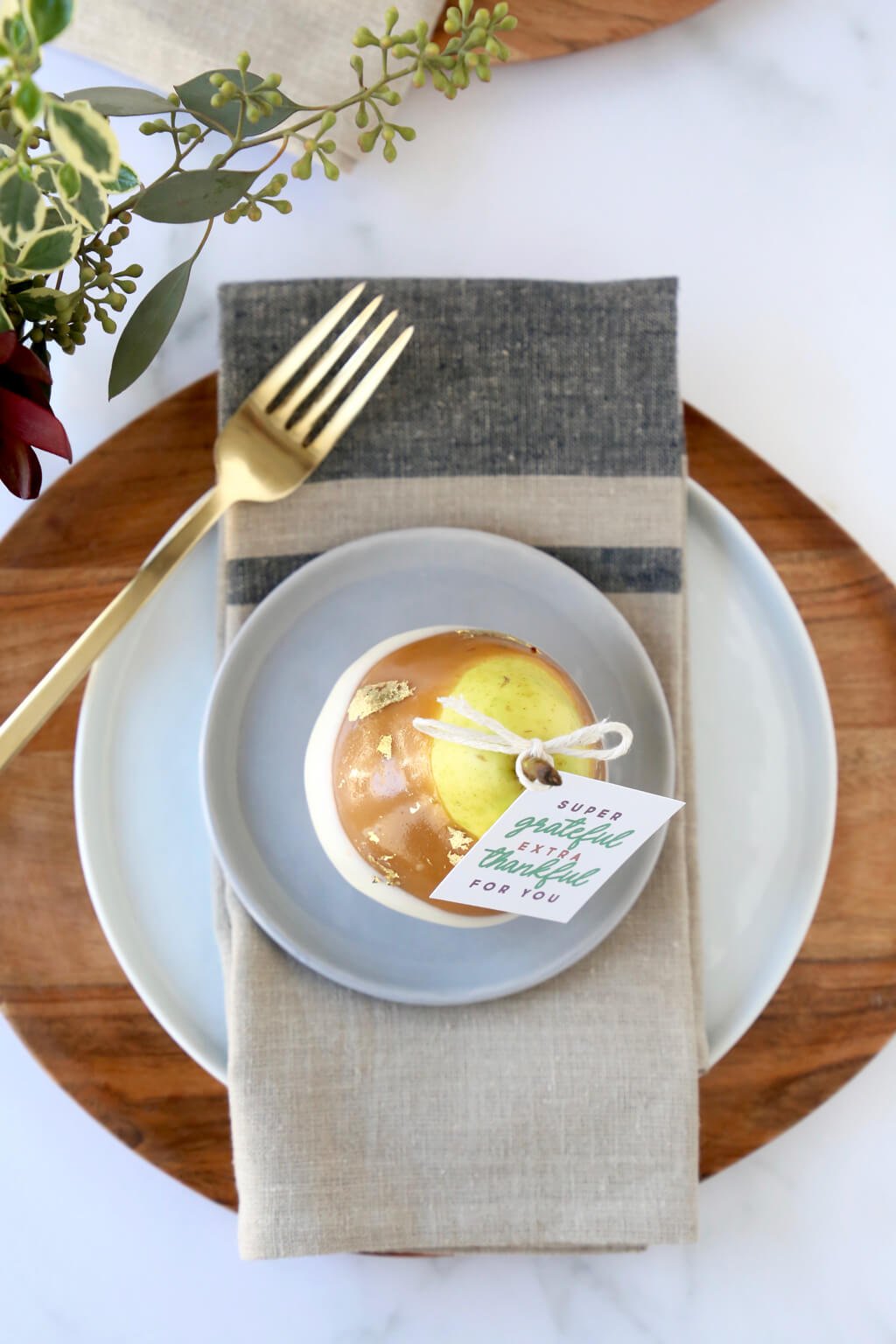 an overhead shot of the caramel pears on a place setting including a place, napkin and fork 