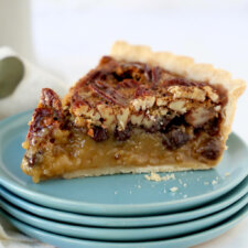 a slice of pecan tart sitting on four dishes