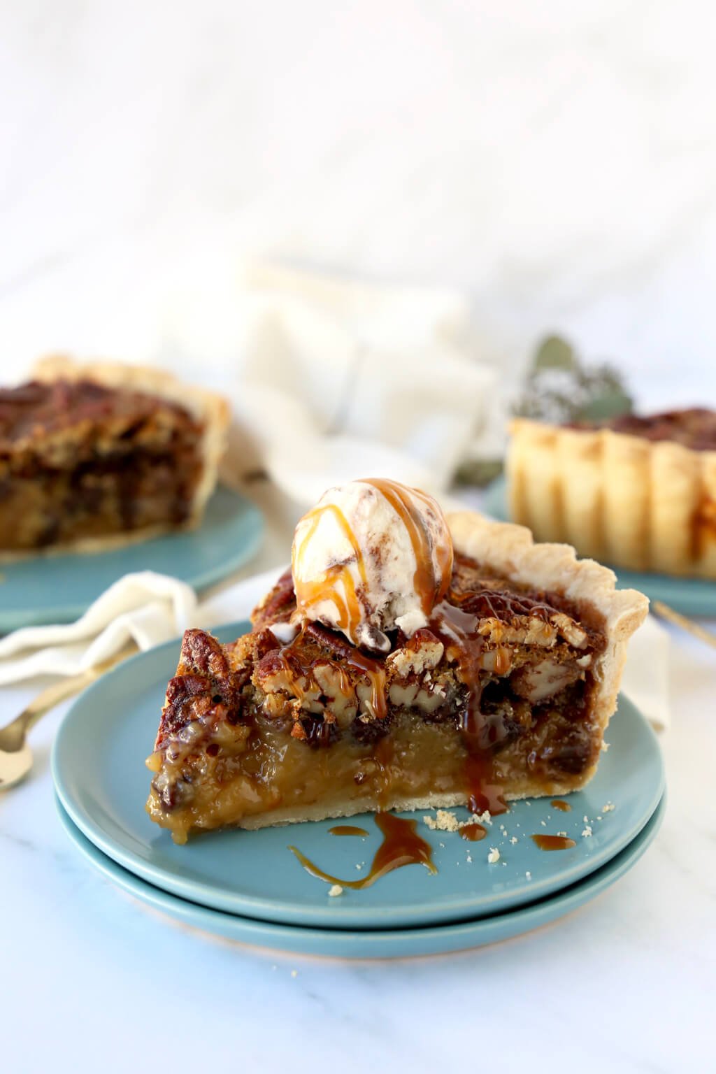three slices of pie and one has a scoop of vanilla ice with a caramel drizzle