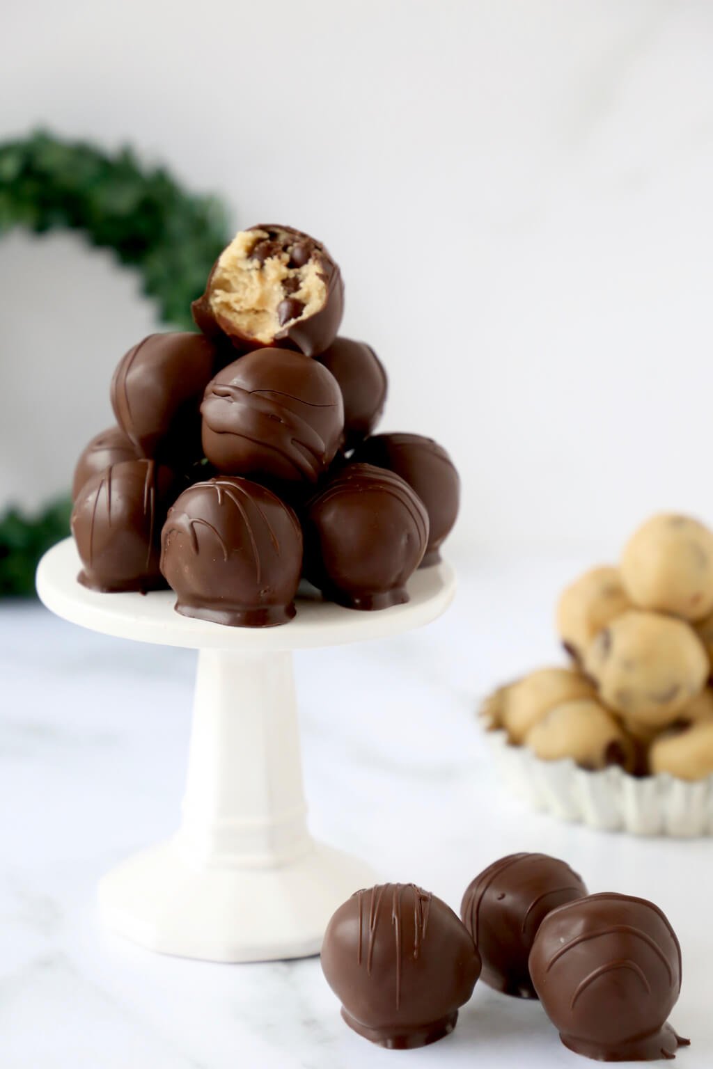 A pile of chocolate chip cookie dough balls on a stand