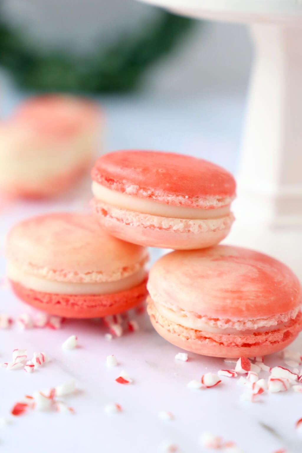 Close up of three peppermint white chocolate french macarons, one stacked on top of the other two