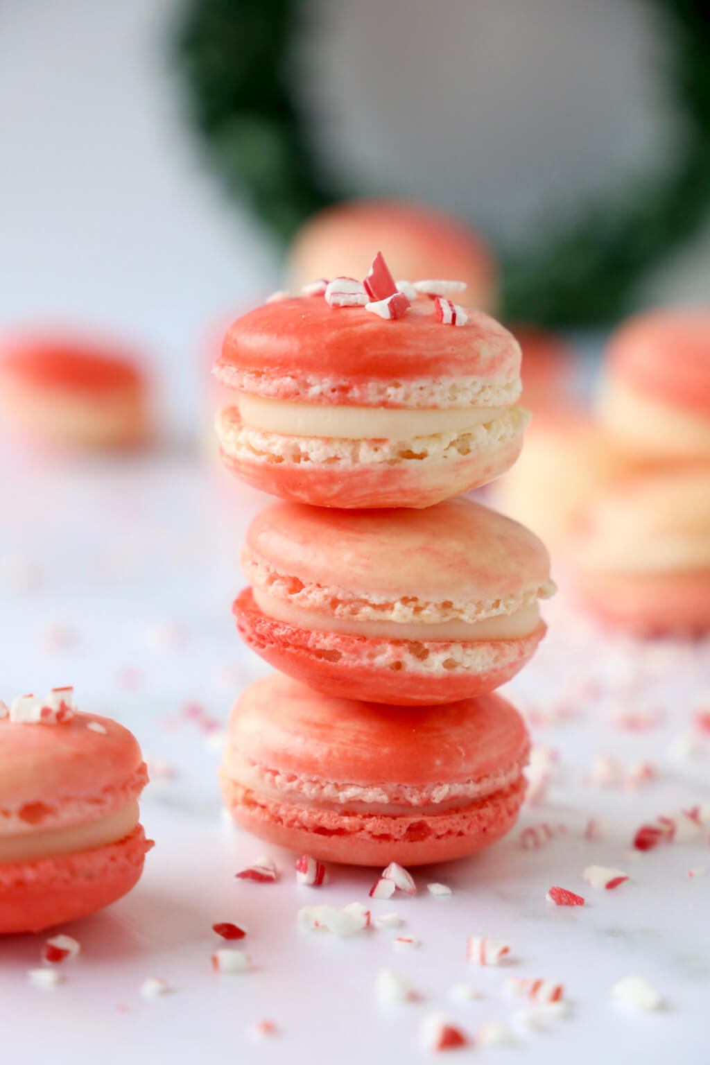 three peppermint white chocolate french macarons stacked on top of each other