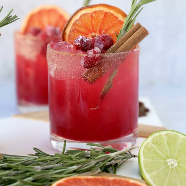 one glass of a christmas cocktail with rosemary, cinnamon and dried grapefruit