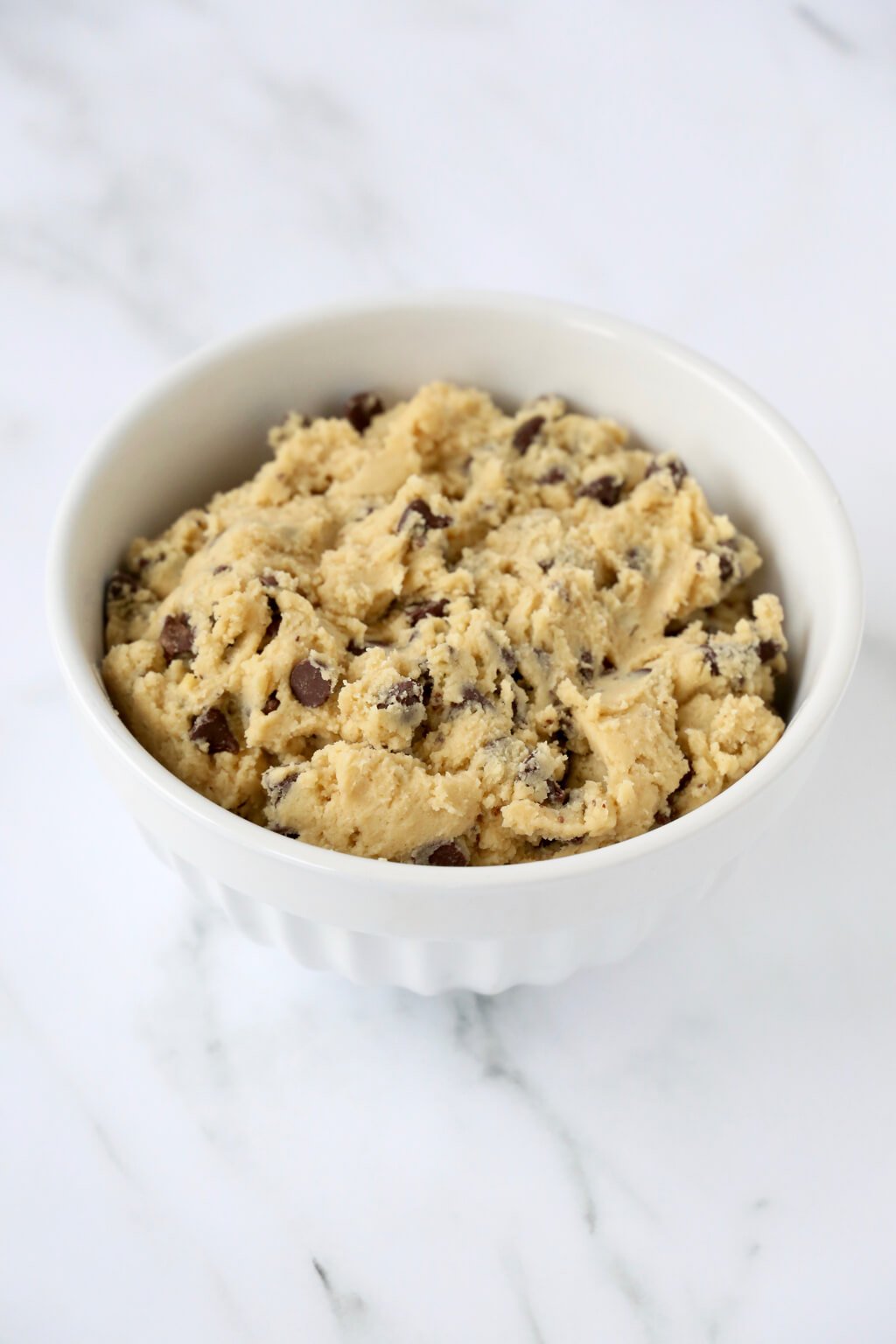 a white bowl filled with chocolate chip cookie dough