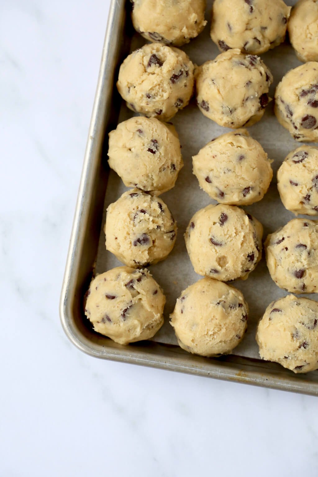 raw cookie dough balls on a baking sheet 