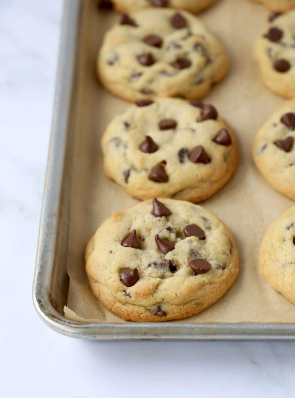 a sheet pan lined with chocolate chip cookies fresh out of the oven 