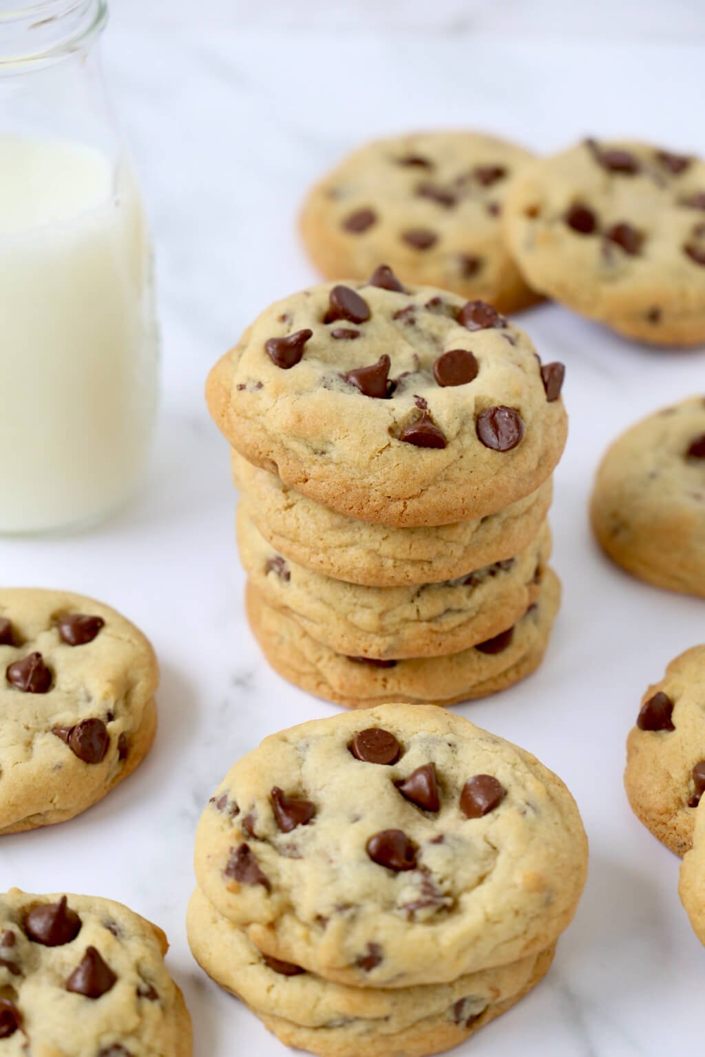 a stack of chocolate chip cookies surround by more chocolate chip cookies 