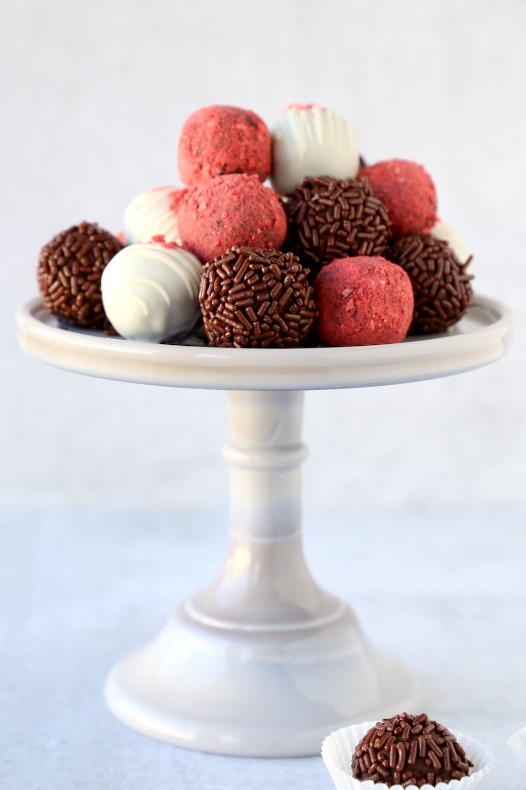 a small gray cake stand with chocolate truffles piled high