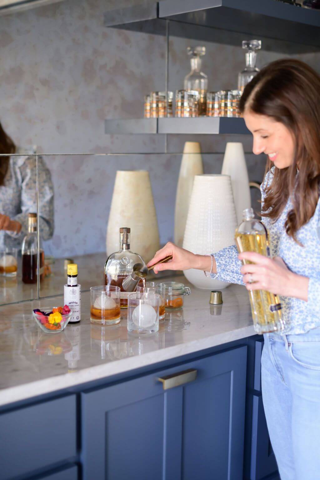 pouring a shot of st. germain liqueur into a glass ice