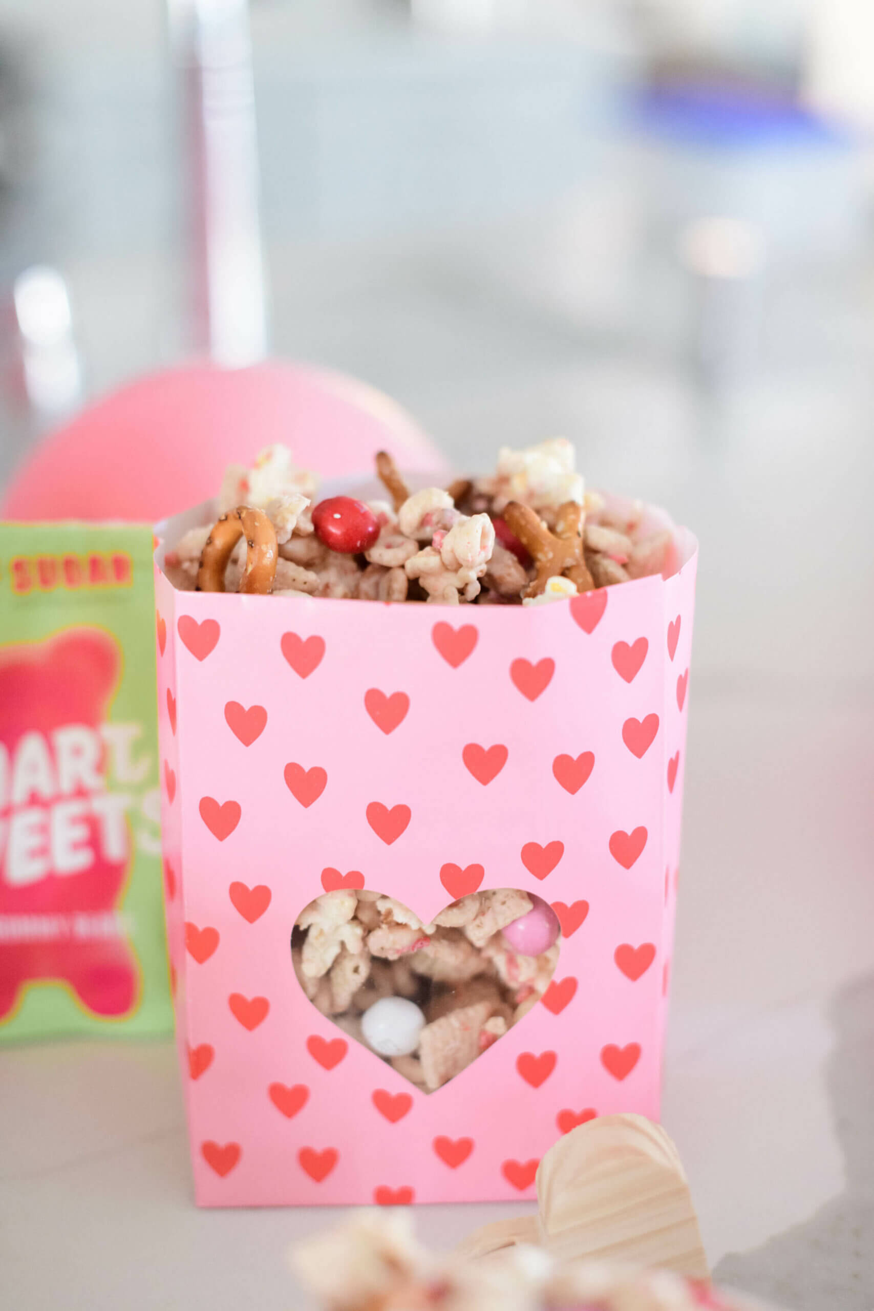 a pink bag with red hearts filling with snack mix