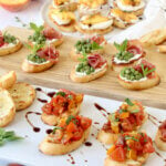 Three platter of assorted bruschetta, toasted bread with tomatoes, peas, prosciutto and peaches.