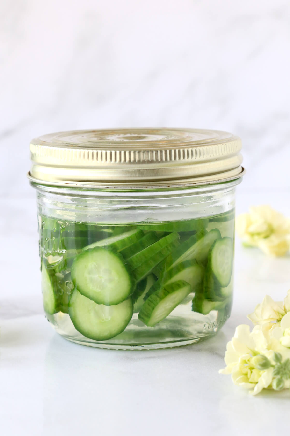 A jar filled with tequila and sliced cucumbers.
