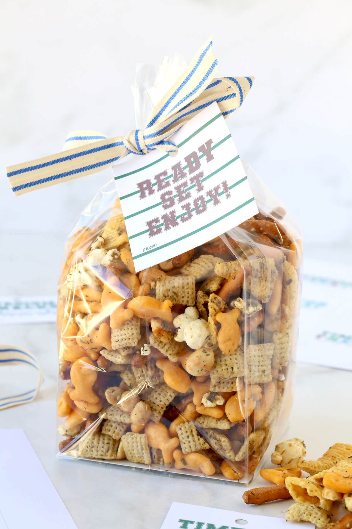 A clear bag of snack mix with a tailgate gift tag.  