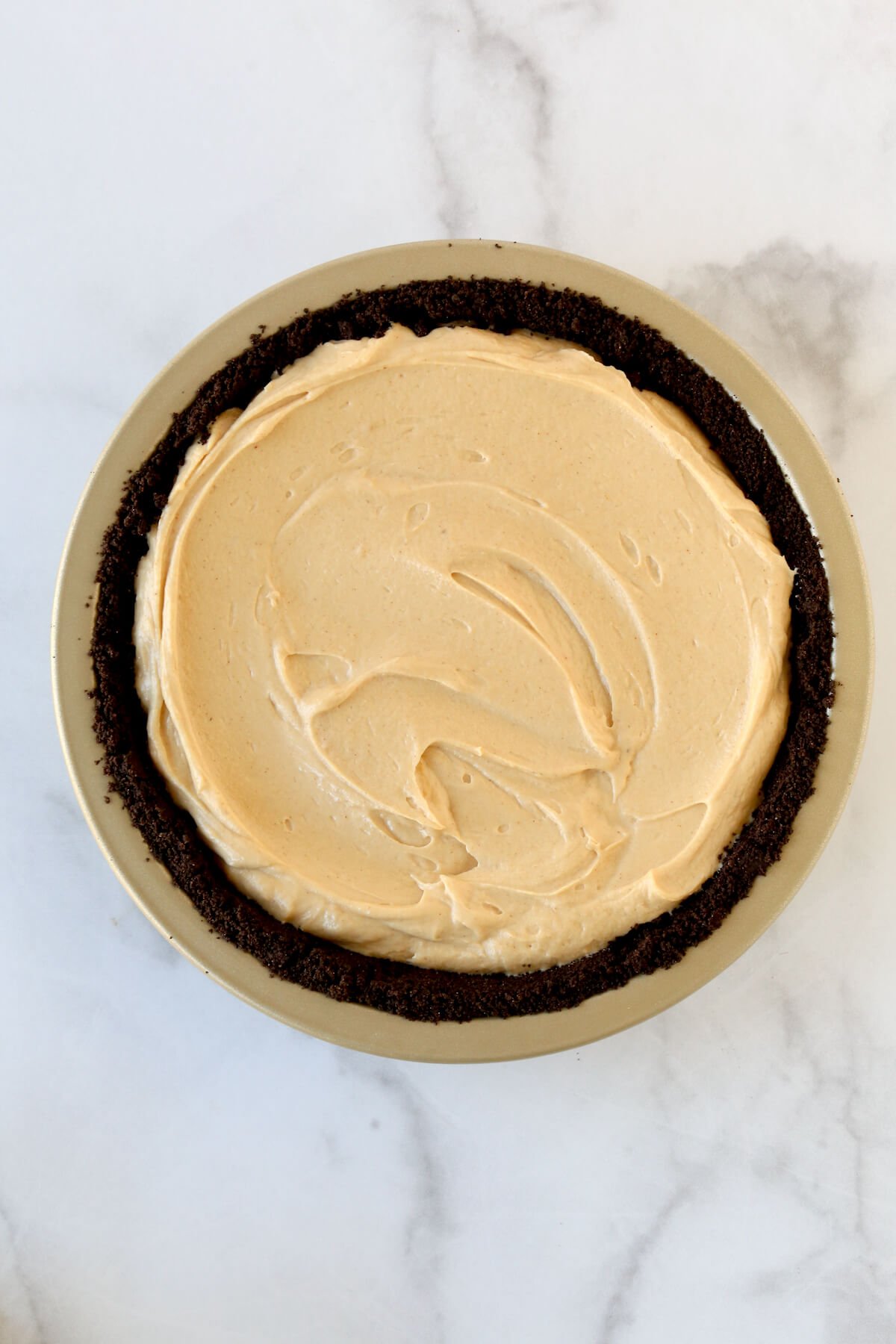 A pie plate with chocolate cookie crust and peanut butter cream filling.