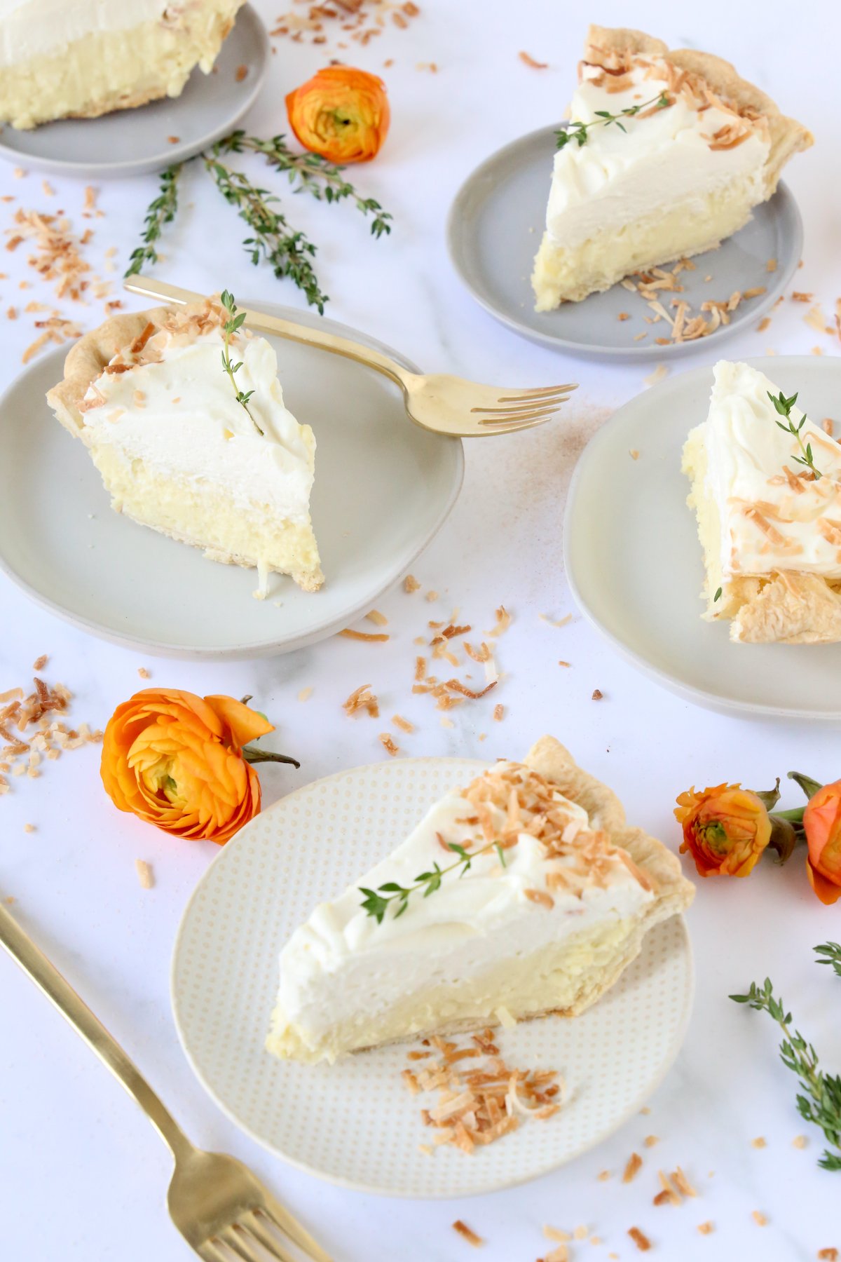 Four slices of pie sprinkled with toasted coconut and fresh flowers.  