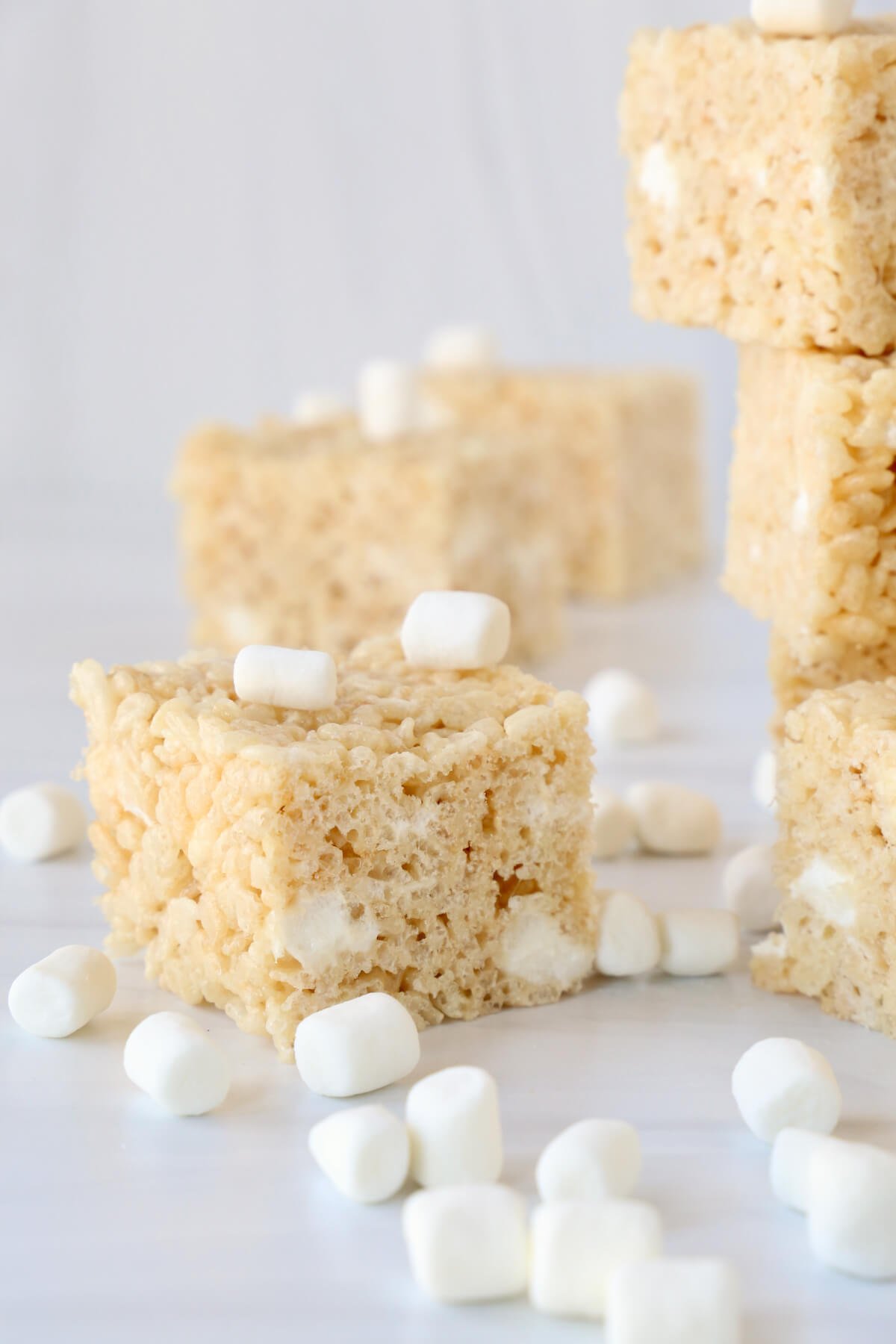 A square of rice krispie treats with marshmallows sprinkled around it. 