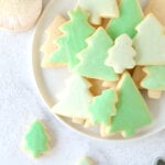 A white plate with green tree cookies.