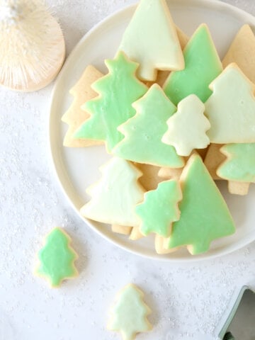 A white plate with green tree cookies.