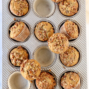 A muffin pan with muffins sitting on top and in the molds.