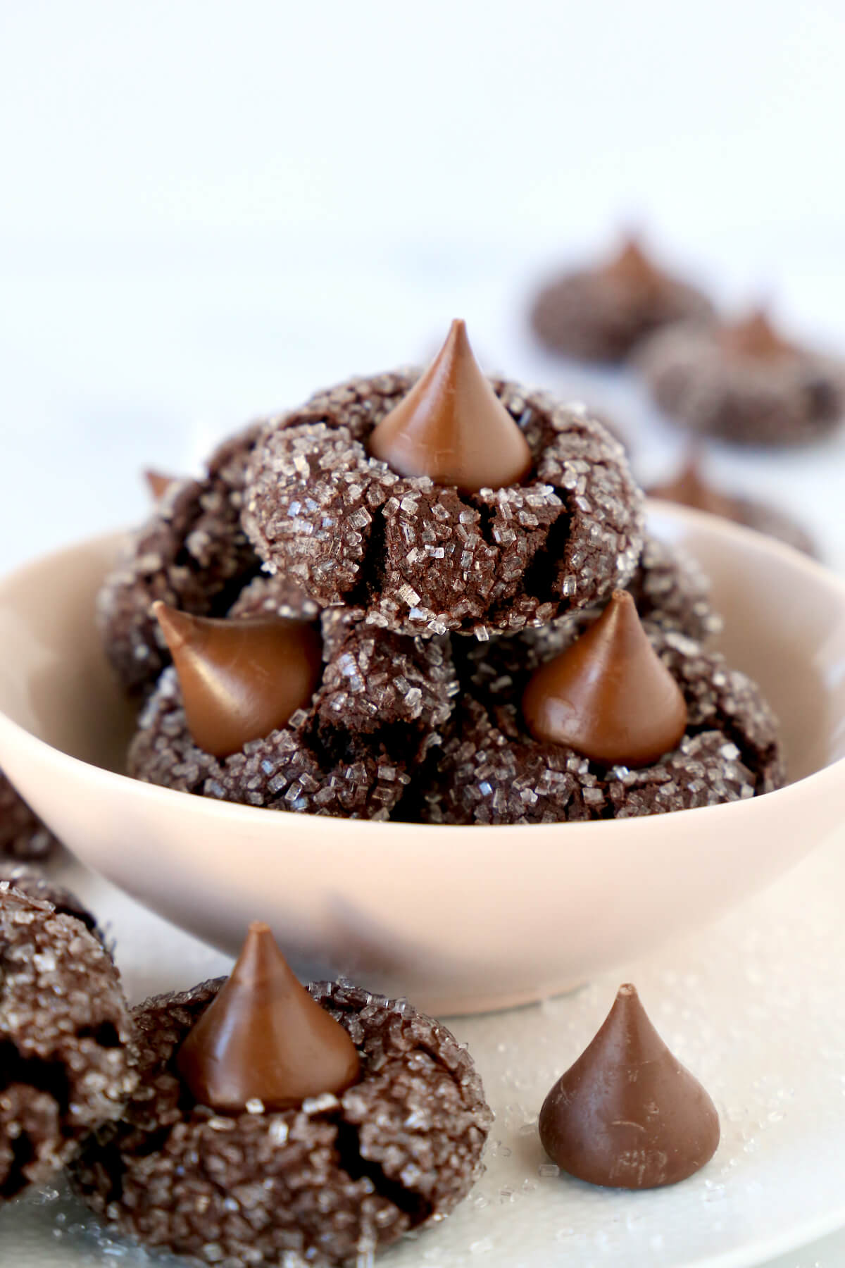 A pink bowl filled with chocolate cookies with chocolate kisses on top.  