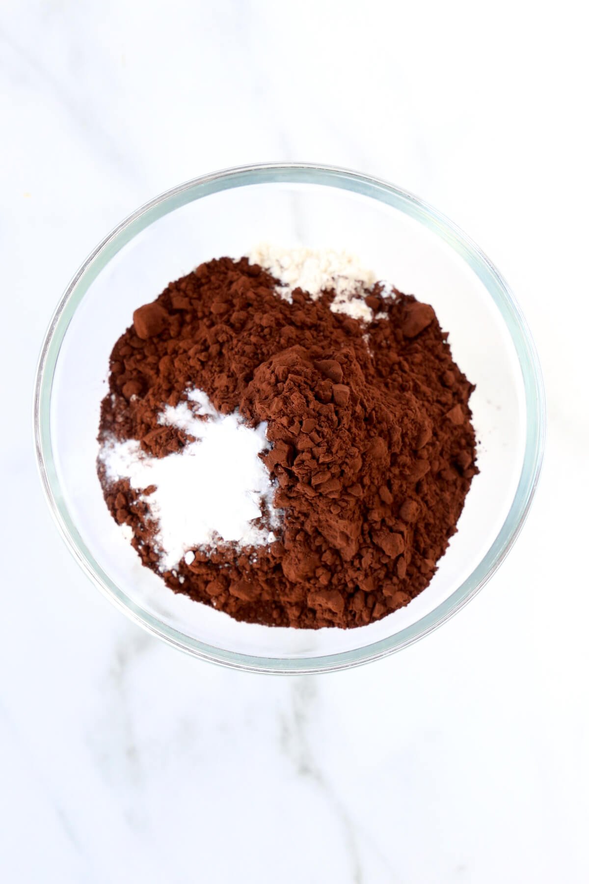 A bowl filled with flour, cocoa powder and baking soda. 