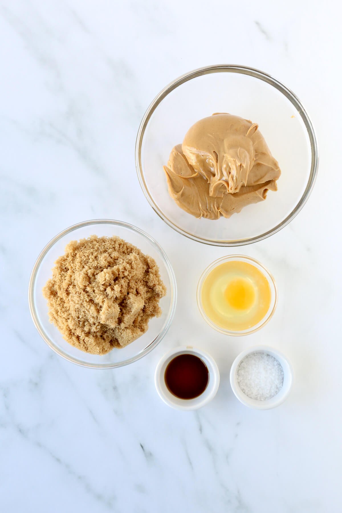 A bowl of peanut butter, brown sugar, egg, vanilla extract and sea salt.