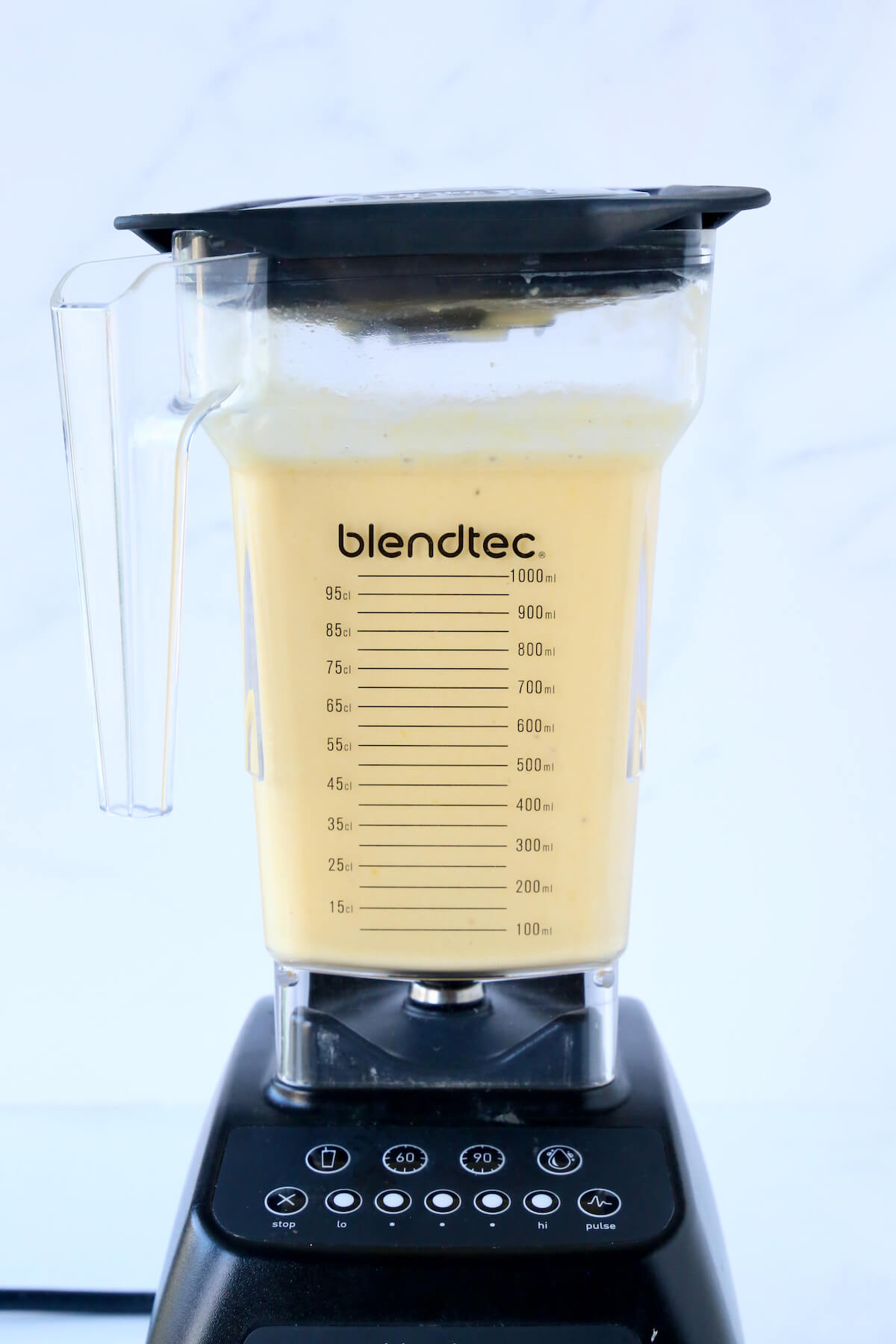 A blender filled with orange smoothie. 