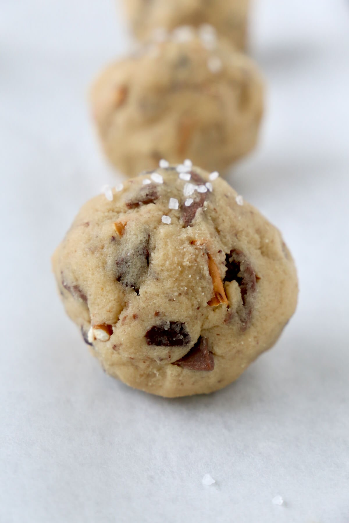 A large round ball of cookie dough with sea salt sprinkled on top.  