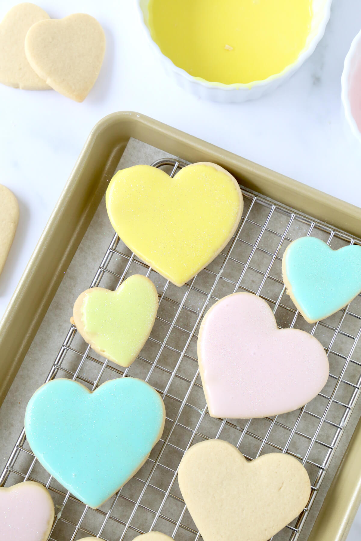 Heart cookies on a tray with a cooling rack.