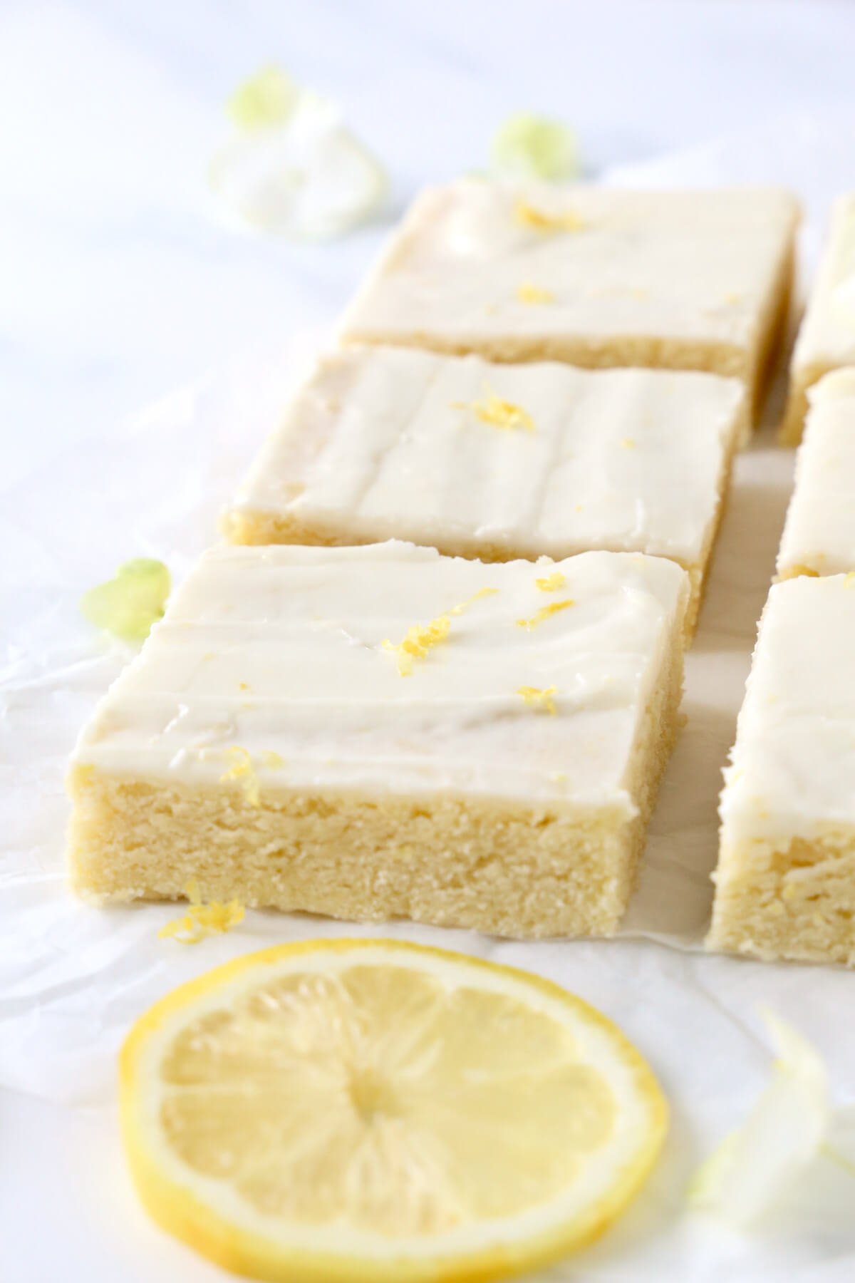 A close up of a cookie square with lemon zest on top.