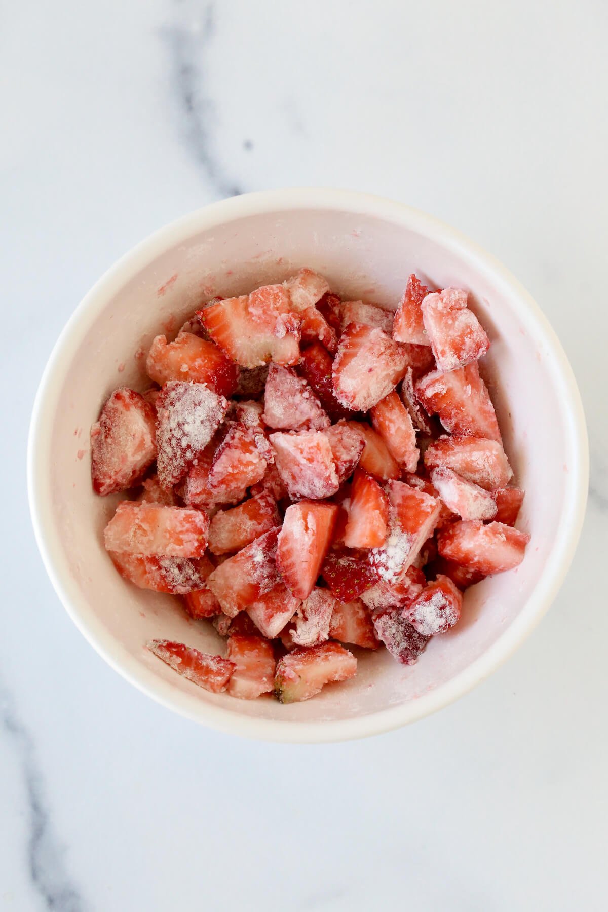 Diced strawberries in a bowl coated in flour.  