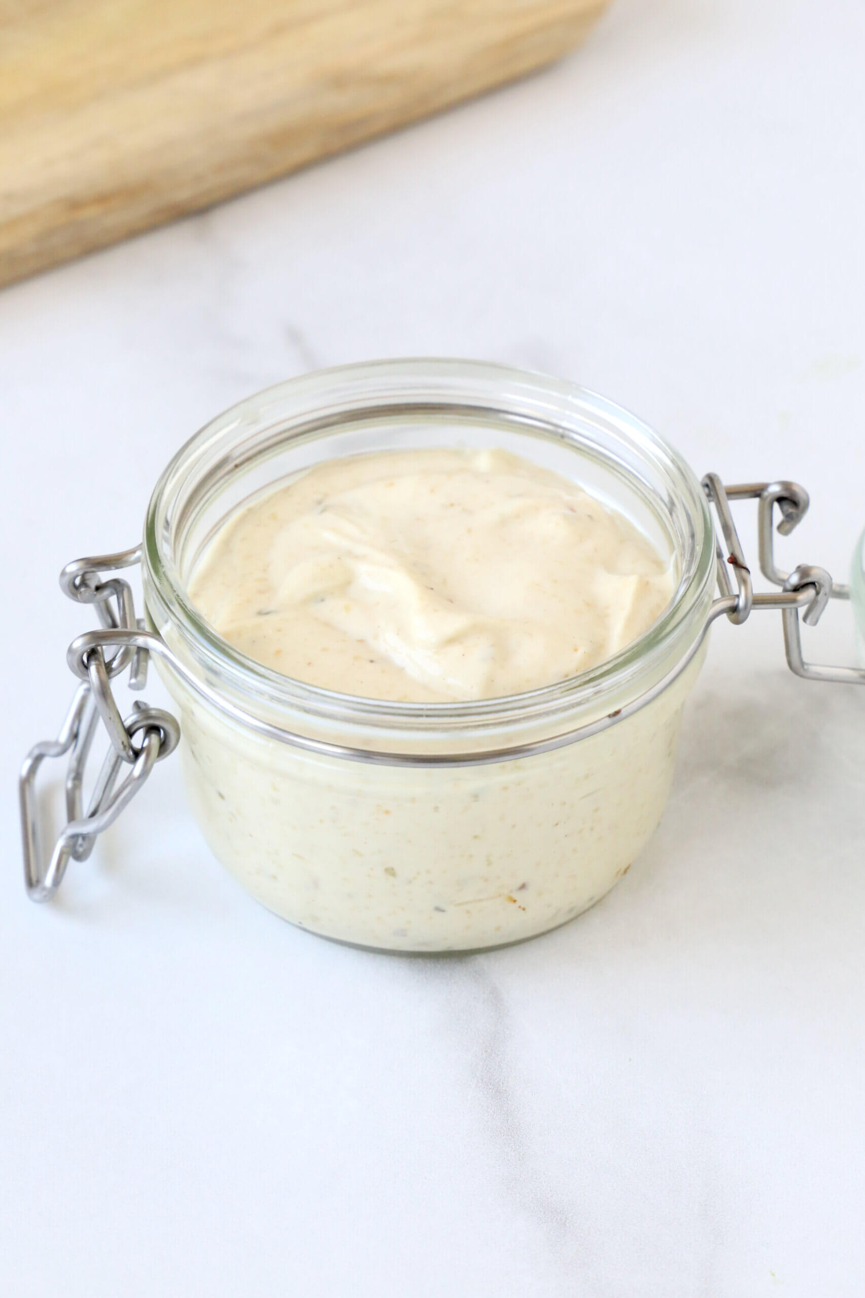 A clear jar filled with a white sandwich spread.  