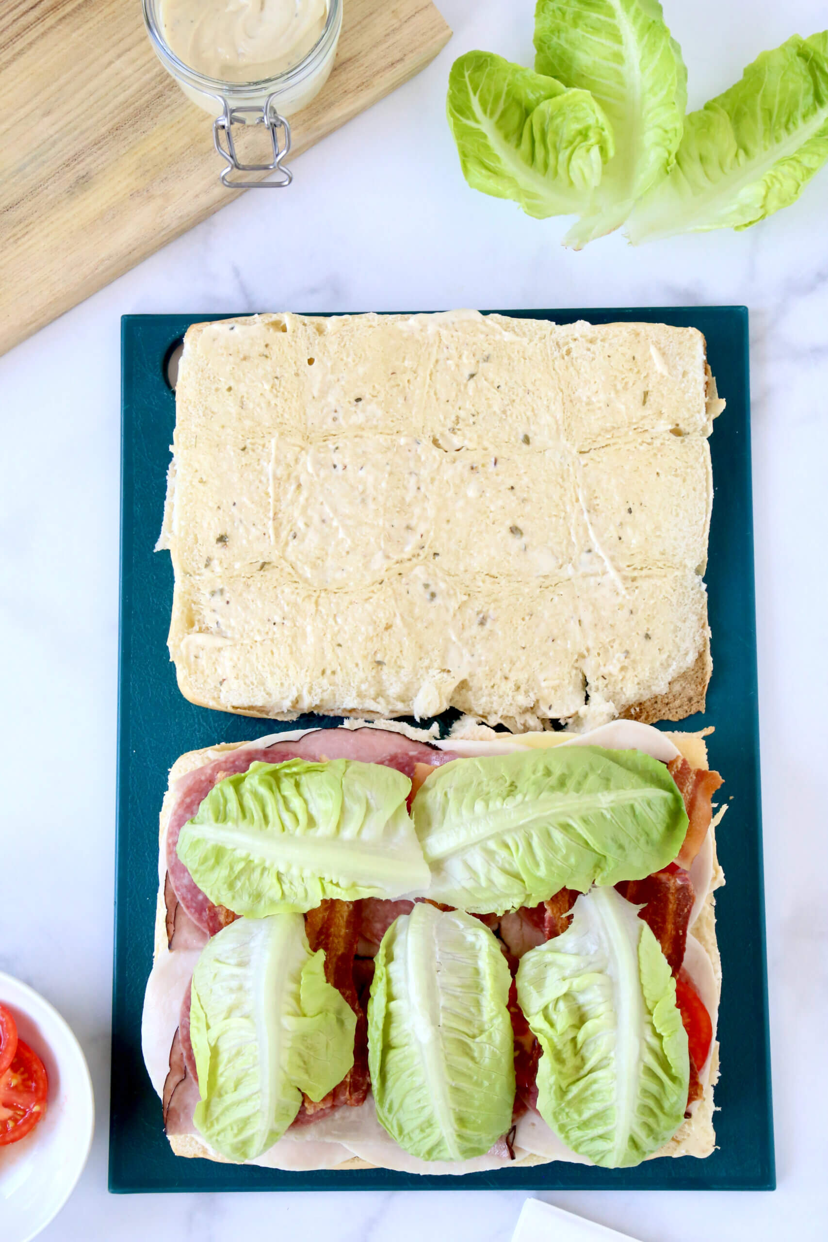 Sandwich bread sliced open and layered with lettuce.