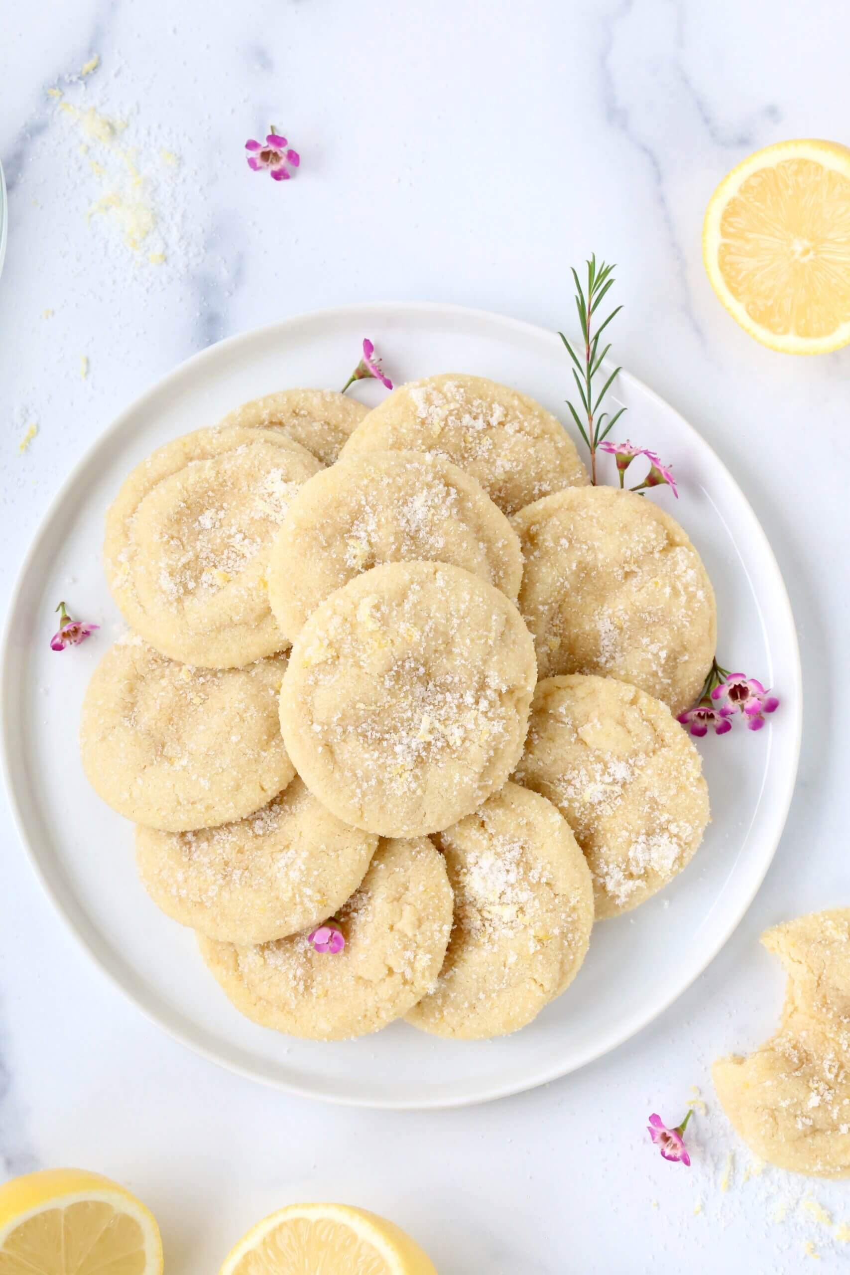A white place with light yellow round cookies stacked on top.