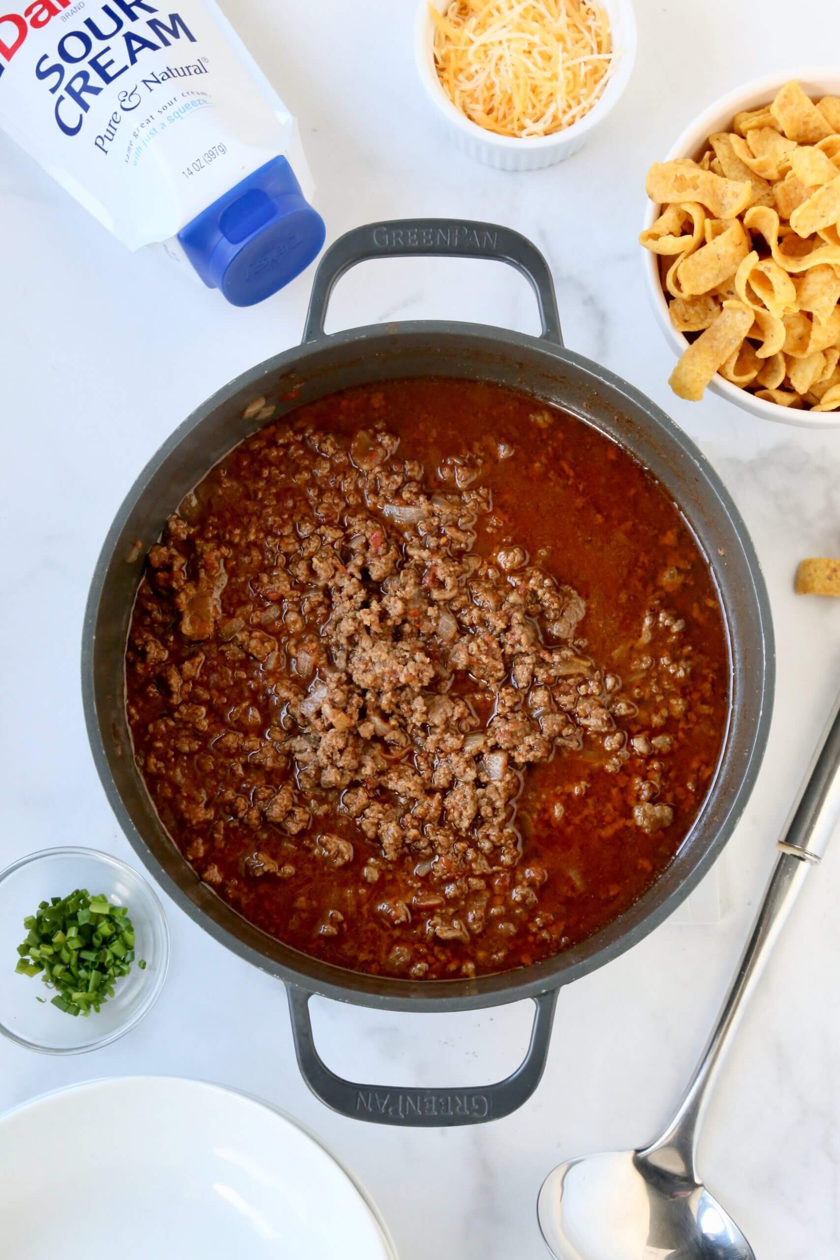 A gray dutch oven filled with a medium brown broth and ground beef.